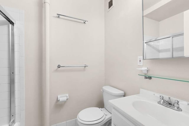 bathroom featuring toilet, an enclosed shower, and vanity