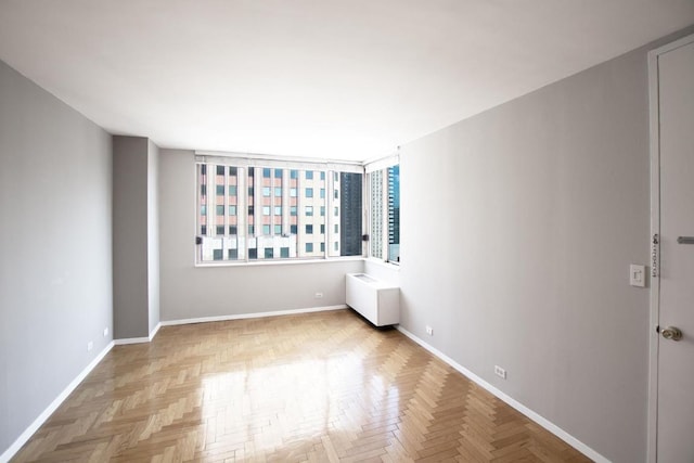 unfurnished room with light parquet flooring and radiator heating unit