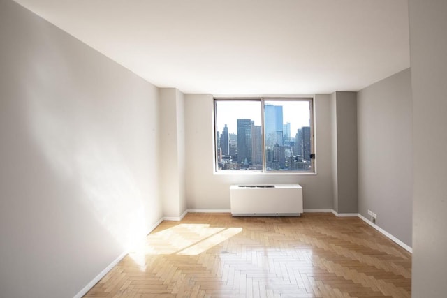 empty room featuring light parquet flooring and radiator heating unit