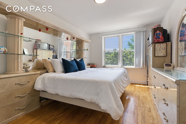 bedroom featuring light wood-style flooring and baseboards