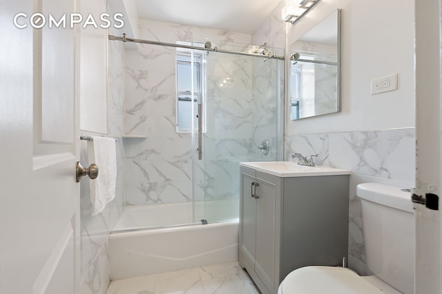 full bathroom with shower / bath combination with glass door, toilet, marble finish floor, and vanity