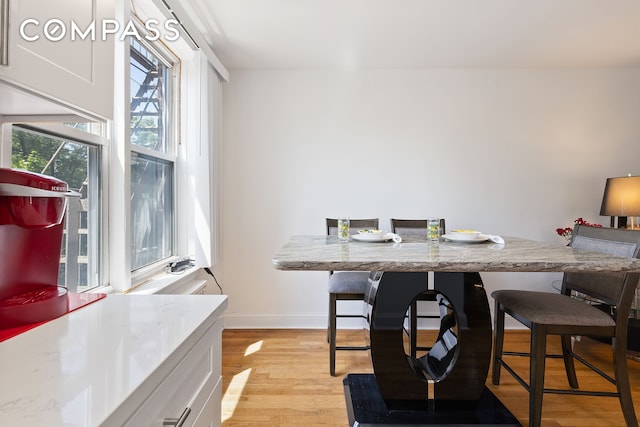 dining area featuring light wood-style floors and baseboards