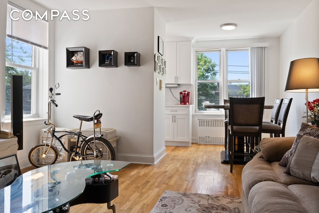 living room featuring radiator, light wood-type flooring, and baseboards