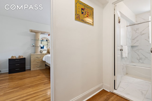 ensuite bathroom with baseboards, wood finished floors, ensuite bath, and a combined bath / shower with marble appearance