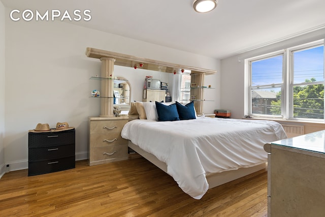 bedroom with light wood-style flooring, multiple windows, and baseboards