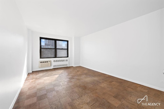 empty room featuring an AC wall unit and radiator heating unit