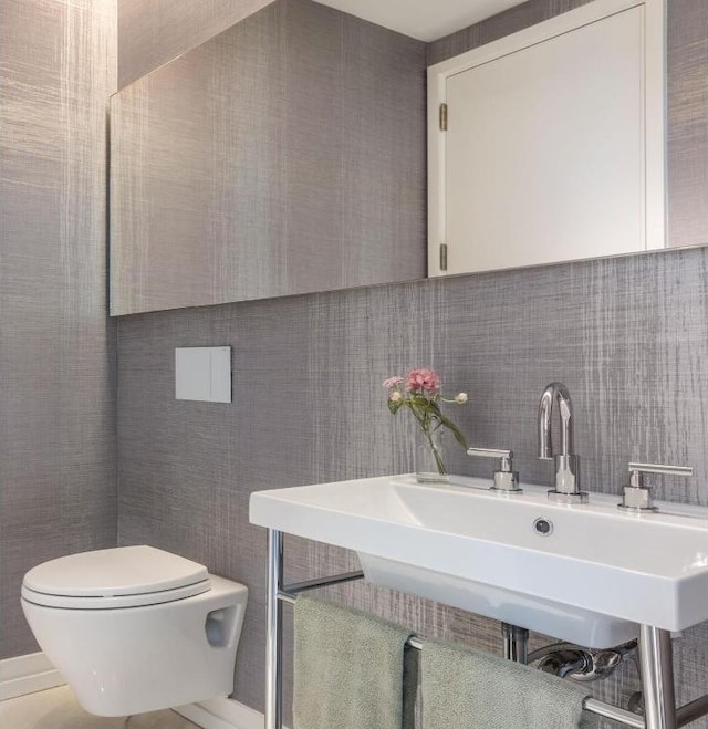 bathroom featuring decorative backsplash, sink, and toilet