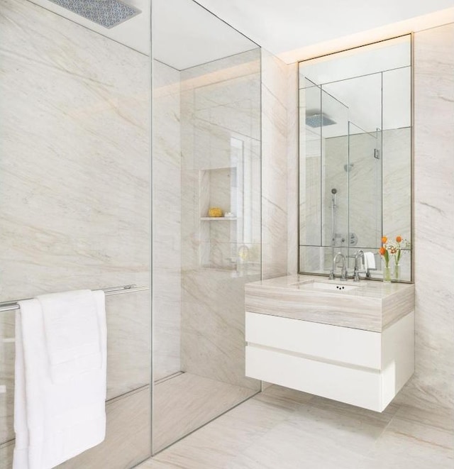 bathroom with tile walls, vanity, and tiled shower