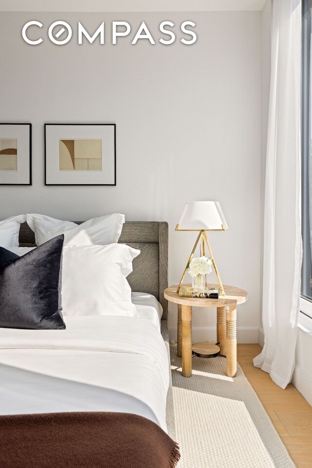 bedroom featuring wood finished floors and baseboards