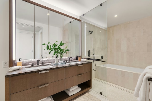 bathroom with tile patterned flooring, double vanity, tiled shower, and a sink