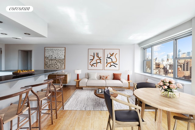 living room with light wood-type flooring, visible vents, and a city view