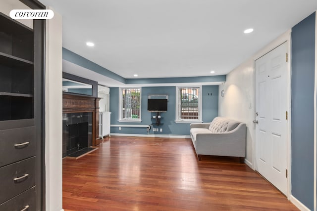 unfurnished living room with a tile fireplace and hardwood / wood-style floors