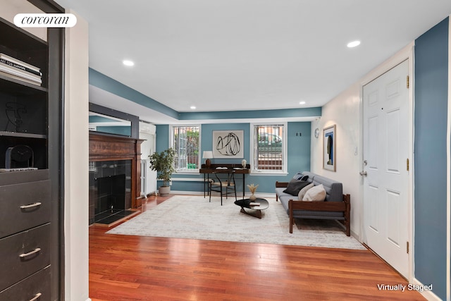 living area featuring a fireplace, recessed lighting, wood finished floors, and baseboards