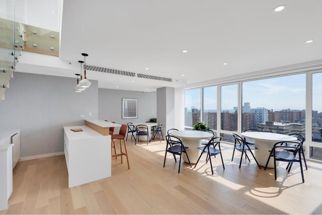 dining area featuring a wall of windows and light wood-type flooring