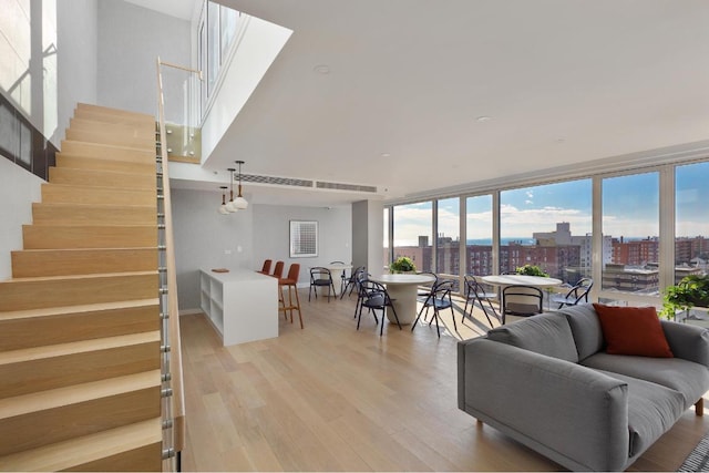 living room with expansive windows, a wealth of natural light, and light hardwood / wood-style floors