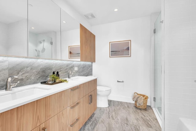 bathroom featuring tasteful backsplash, vanity, walk in shower, and toilet