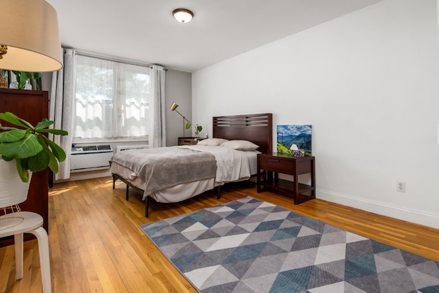 bedroom with baseboards and hardwood / wood-style flooring