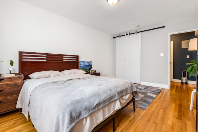 bedroom featuring a closet, light wood-type flooring, and baseboards