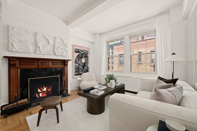 living area with beamed ceiling and a premium fireplace