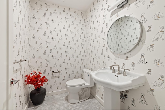 bathroom with baseboards, wallpapered walls, toilet, and tile patterned floors