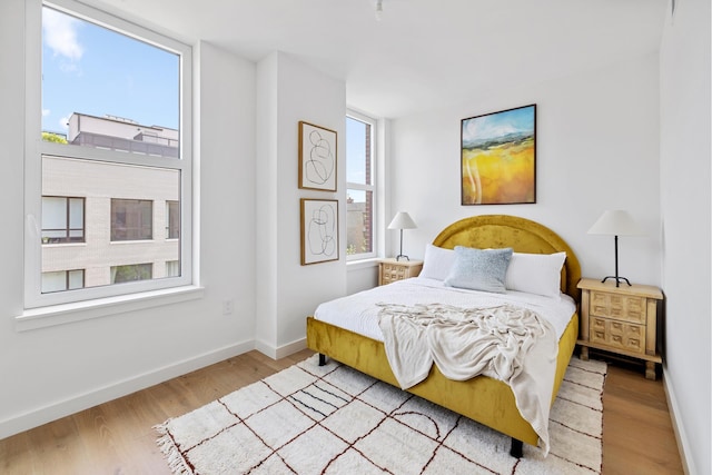 bedroom with light wood-type flooring and baseboards