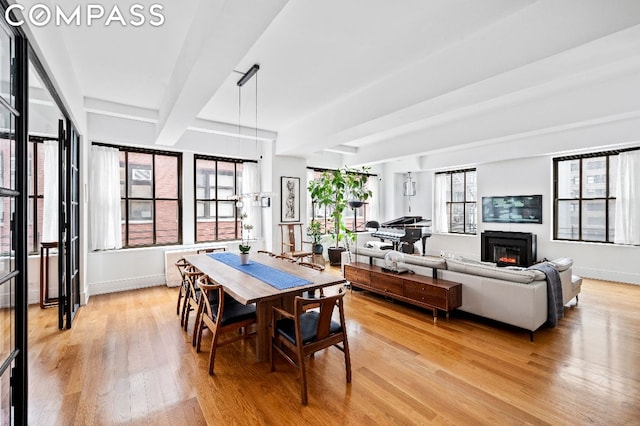 dining area featuring beamed ceiling and light hardwood / wood-style flooring