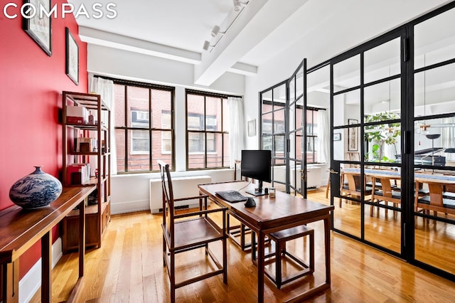 office space with wood-type flooring and rail lighting