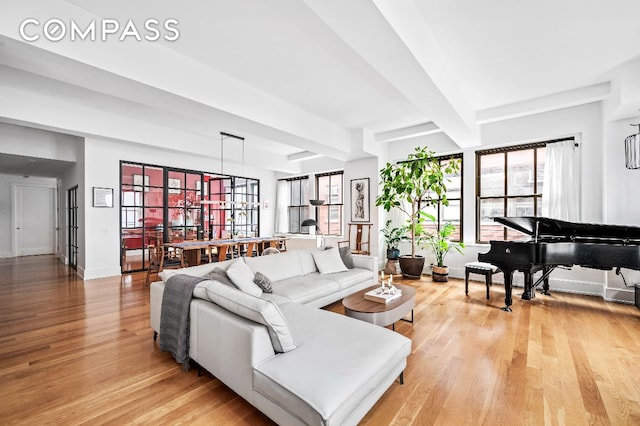 living room featuring beamed ceiling and light wood-type flooring