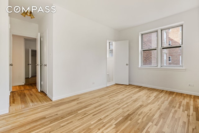 unfurnished room with light wood-style flooring and baseboards