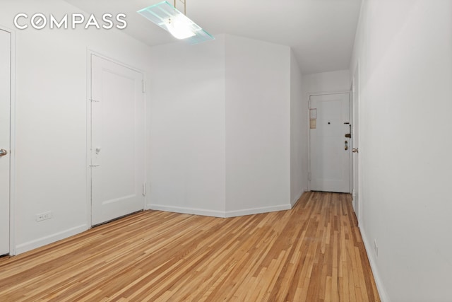 spare room with light wood-type flooring and baseboards