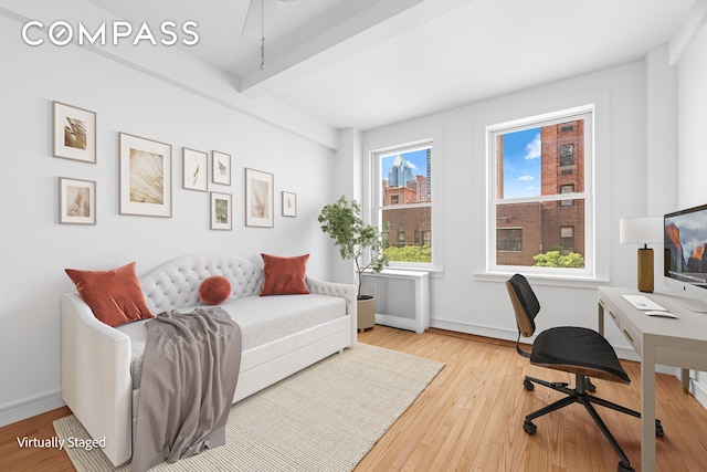 office area featuring hardwood / wood-style floors, beam ceiling, radiator heating unit, and baseboards