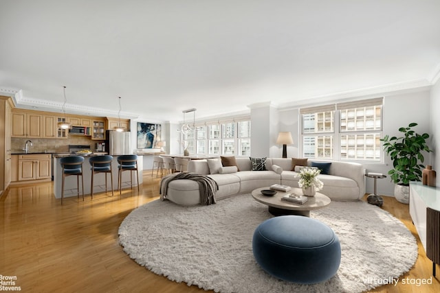 living room with light wood-style flooring and crown molding