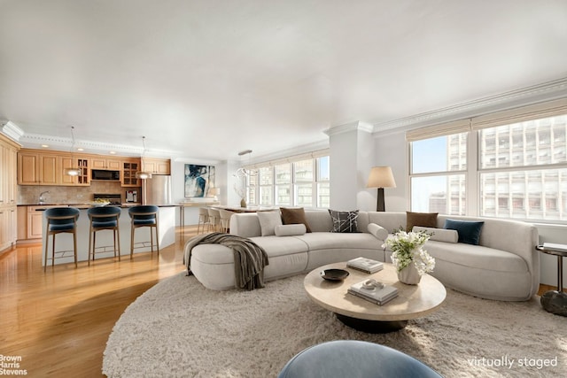 living room with crown molding and light wood finished floors