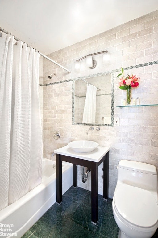 full bathroom with tile patterned floors, shower / bath combination with curtain, toilet, and a sink