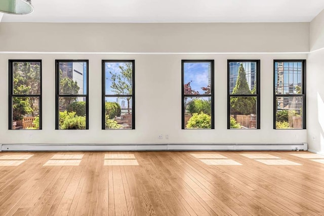 unfurnished room featuring a baseboard radiator and wood-type flooring