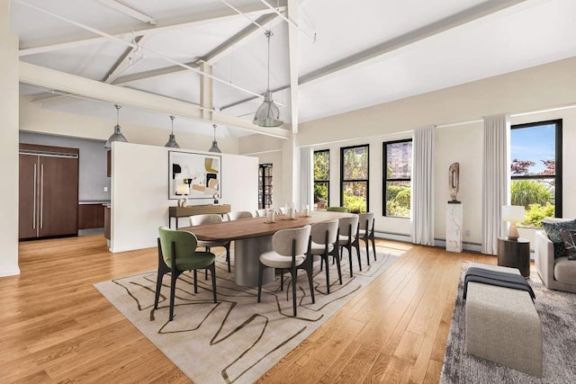 dining space with high vaulted ceiling, beamed ceiling, a baseboard radiator, and light wood-style flooring