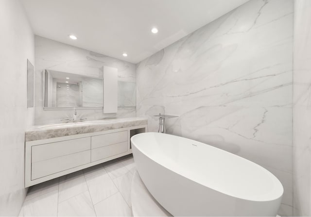 bathroom featuring vanity, recessed lighting, and a freestanding bath