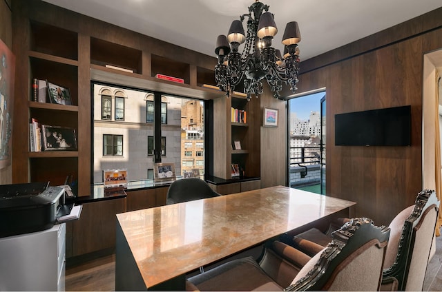 office featuring wood walls, an inviting chandelier, and wood finished floors