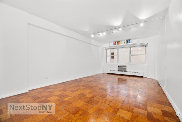 unfurnished room featuring rail lighting, baseboards, and baseboard heating