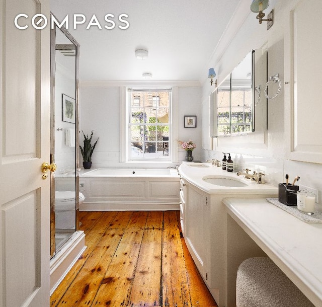 full bathroom featuring ornamental molding, toilet, wood-type flooring, and vanity