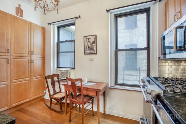 dining room featuring a wealth of natural light, a notable chandelier, and light wood-type flooring