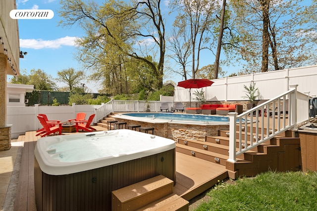 exterior space with a fenced in pool, outdoor lounge area, stairway, a hot tub, and a fenced backyard