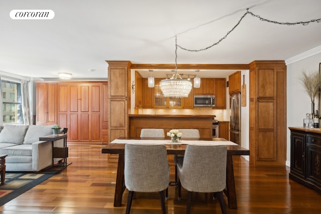 dining area featuring dark wood-type flooring, crown molding, and an inviting chandelier