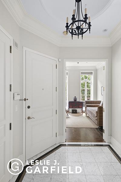 entrance foyer with a chandelier, crown molding, and a tray ceiling