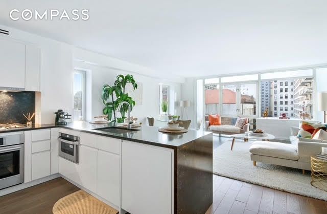 kitchen with sink, appliances with stainless steel finishes, dark stone countertops, dark hardwood / wood-style floors, and white cabinets