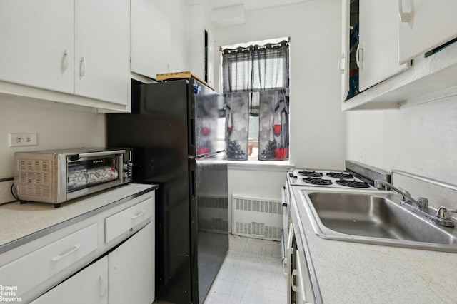 800 Grand Concourse Unit Gms, New York City, NY 10451 - kitchen featuring radiator, a sink, white cabinetry, and light countertops