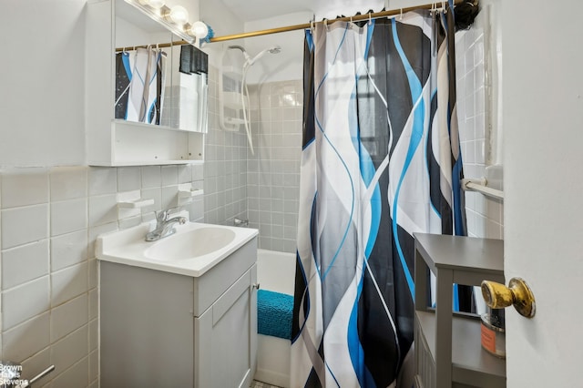 bathroom with shower / bath combination with curtain, vanity, and tile walls