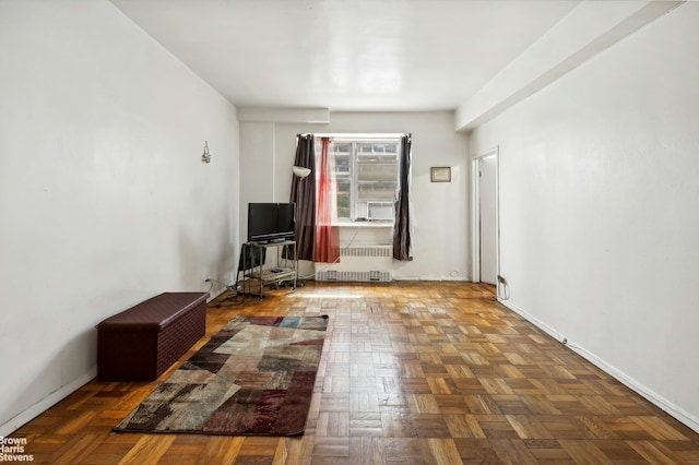 unfurnished living room featuring radiator heating unit and baseboards