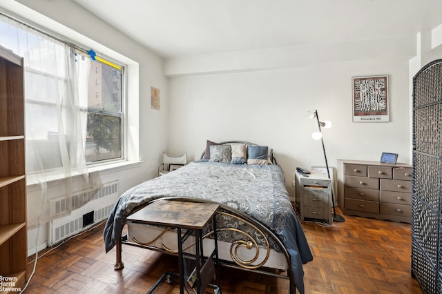 bedroom featuring radiator heating unit and multiple windows