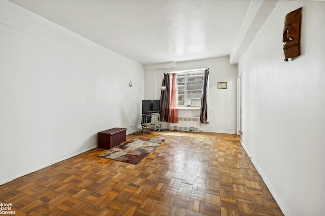 empty room featuring radiator and baseboards